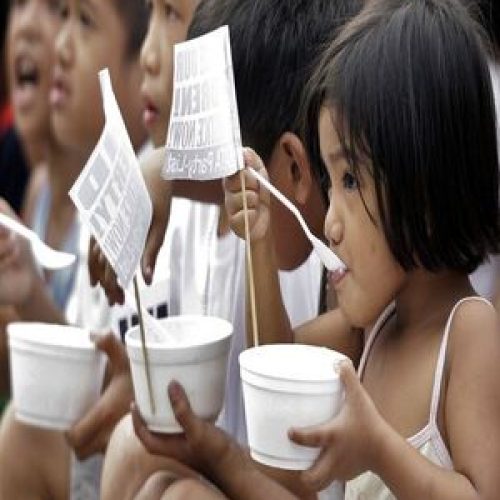 Children eat free porridge distributed by a child welfare group calling to end hunger and malnutrition, on World Day for Social Justice February 20, 2010 in Tondo district, Manila. REUTERS/Rouelle Umali (PHILIPPINES - Tags: SOCIETY)